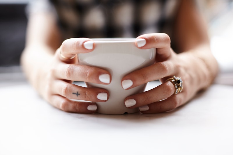 A woman who has a bipolar disorder with white painted nails using her phone