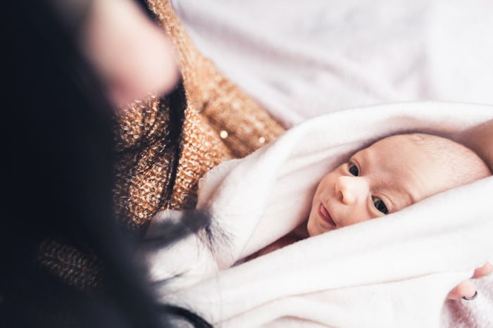 A mother holding her baby in a white towel after a shower