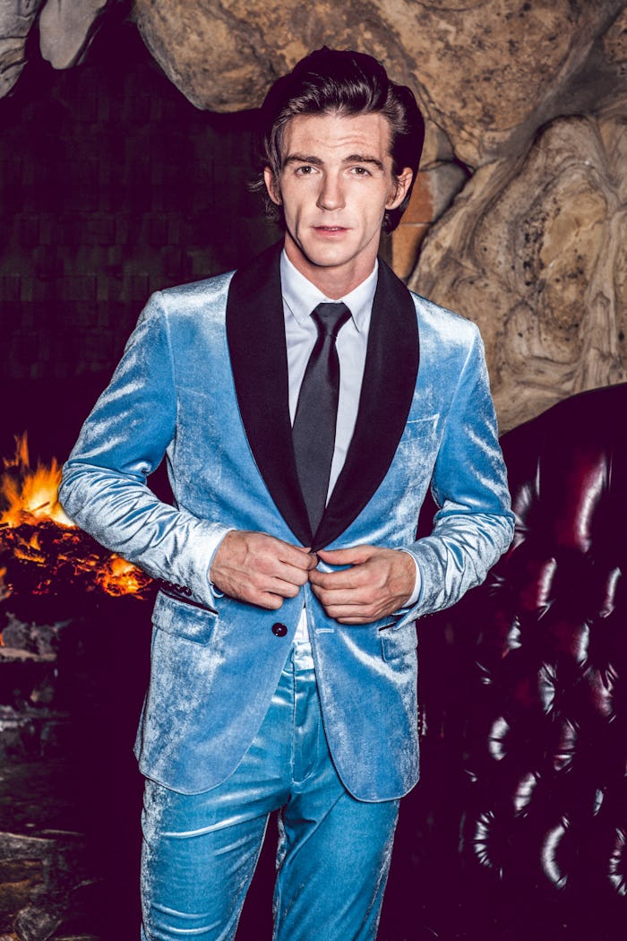 A young man posing in a light blue formal suit