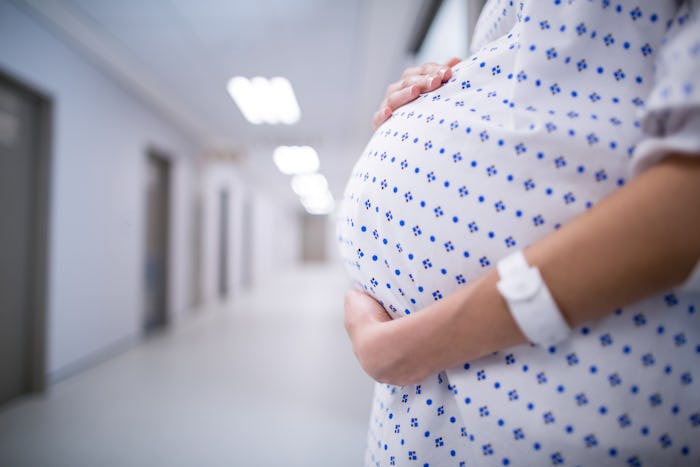 A pregnant woman in a hospital gown in a hospital who is addicted to opioids 