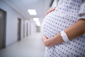 A pregnant woman in a hospital gown in a hospital who is addicted to opioids 