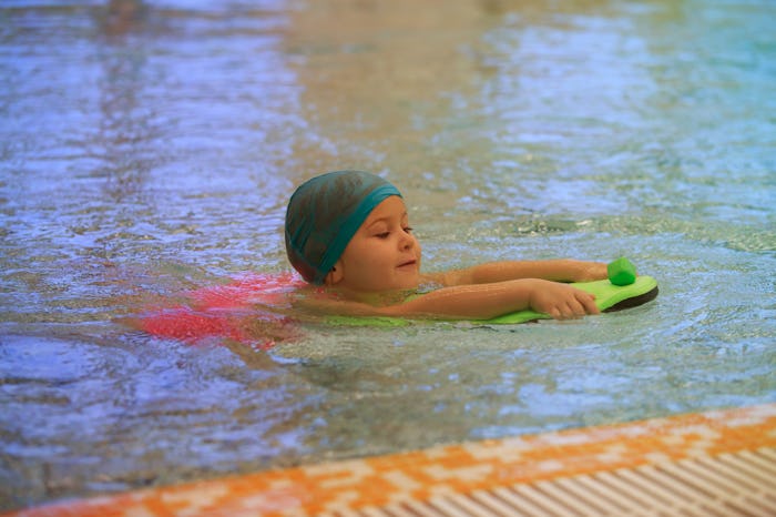 A girl with a swimming cat in a swimming pool during one of her summer activities