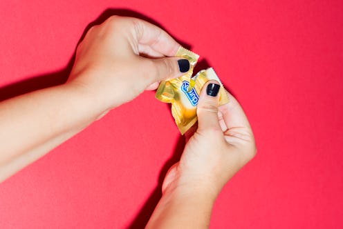 A woman's hands opening a Durex condom package