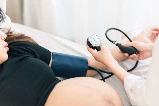 Pregnant woman getting her pressure measured at the doctors office