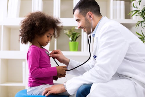 Pediatrician using a stethoscope on a child