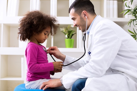Pediatrician using a stethoscope on a child
