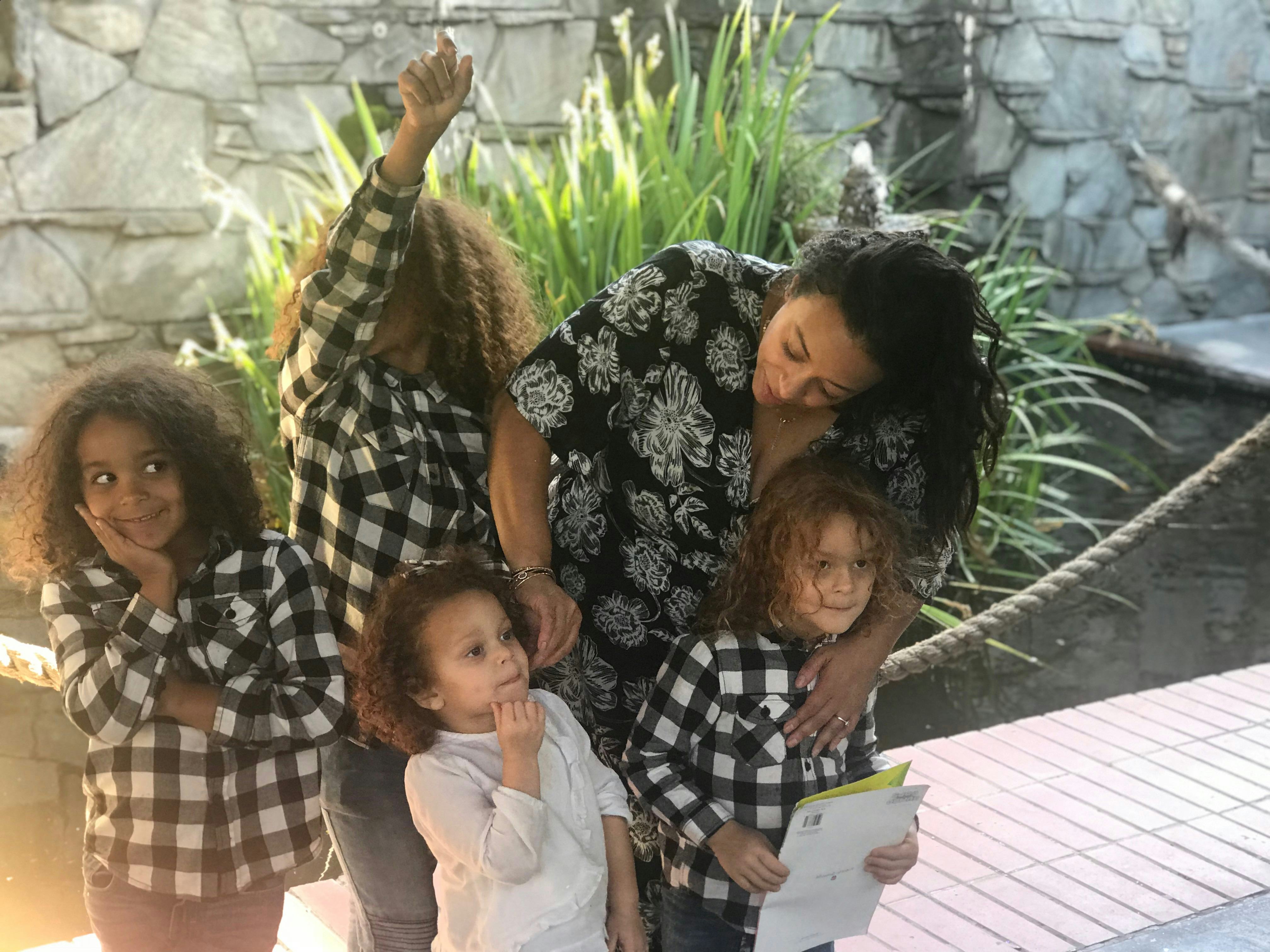 A mother standing with her four children