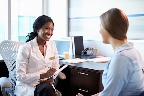 A young lady sitting and talking with her doctor