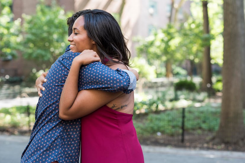 Happy woman hugging her friend and smiling