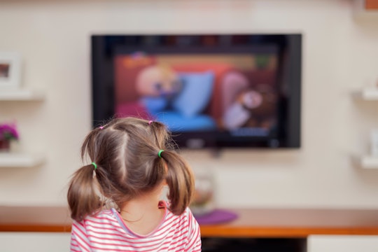 A kid watching TV with a blurred screen