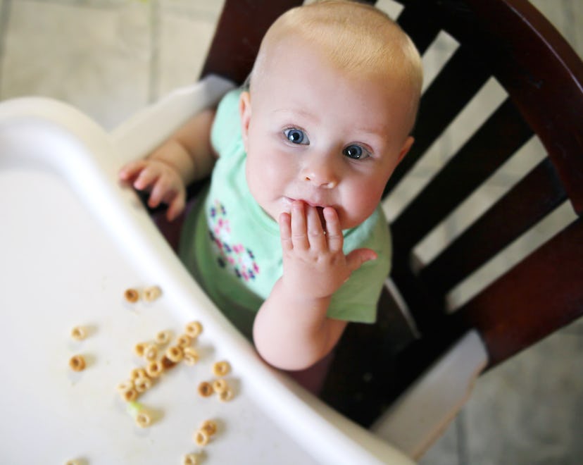a baby eats cheerios