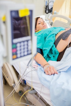 A pregnant woman lying on a hospital bed