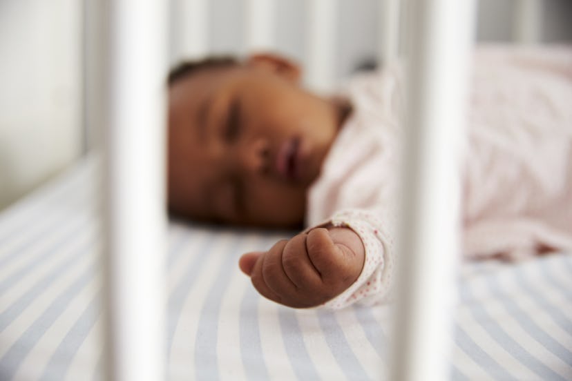 A baby is peacefully sleeping in its crib.