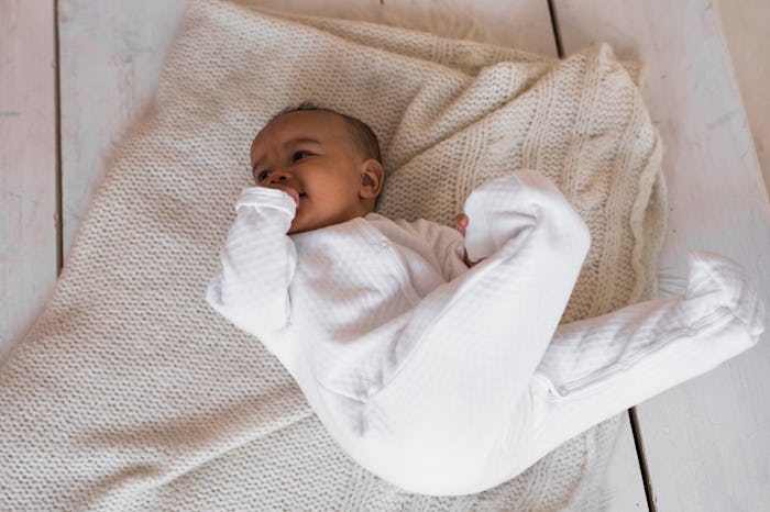 baby wearing white feet pajamas