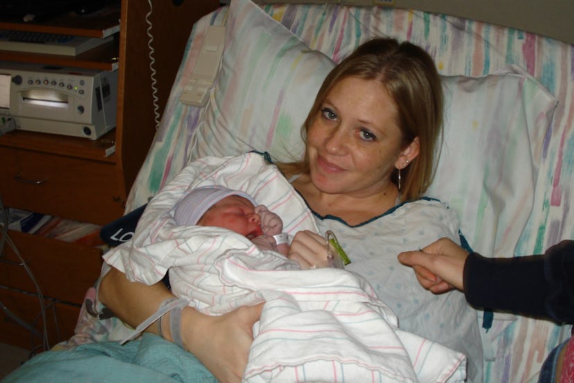 A woman in the hospital bed right holds a newborn