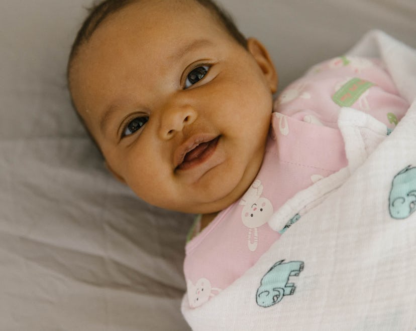 Baby Charlotte laying in bed covered by her blanket