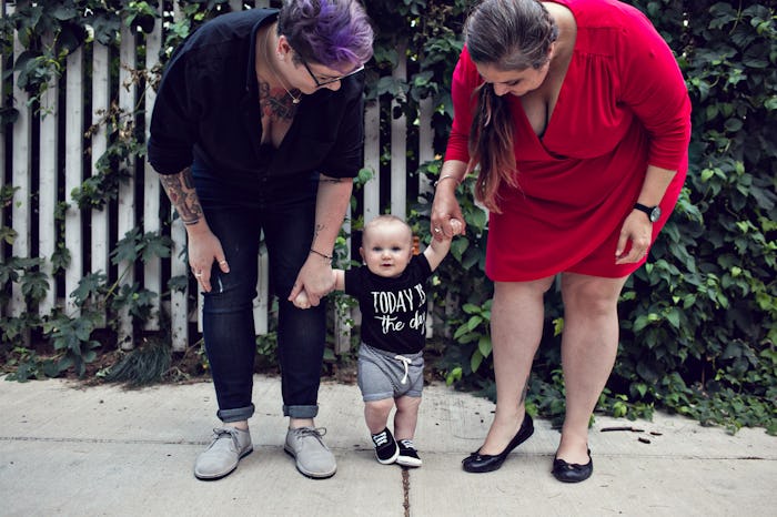 Dese'Rae L. Stage and her partner holding hands with their baby while he's standing