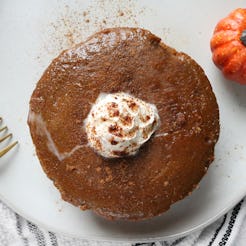 Pumpkin pie served with a fork and a small pumpkin decoration 