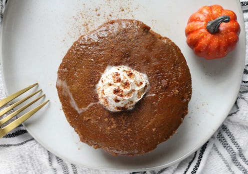 Pumpkin pie served with a fork and a small pumpkin decoration 