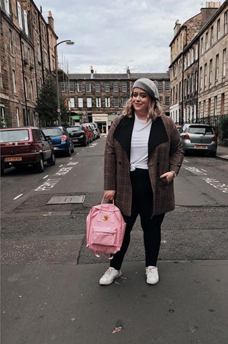 Plus-Size Influencer Amanda Apparel wearing a gray beret and a coat while posing for picture.