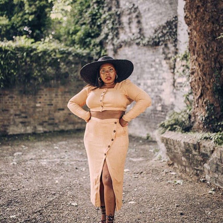 Chloé Pierre wearing beige two piece with a black hat while posing for picture.