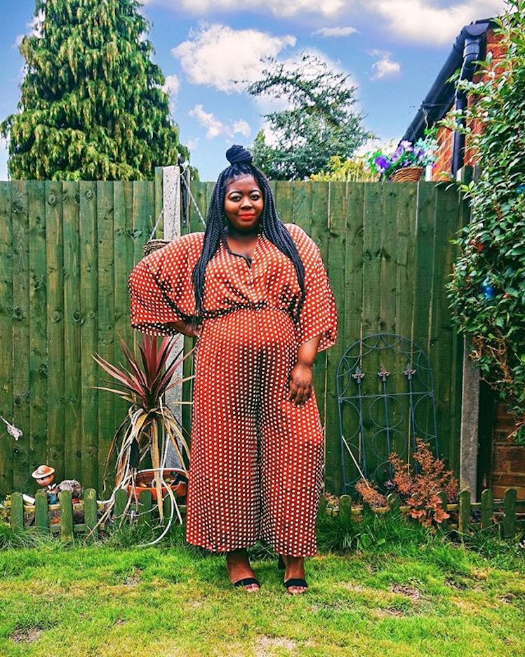 Plus-Size Influencer Stephanie Yeboah posing in her backyard in polka dot jumpsuit.