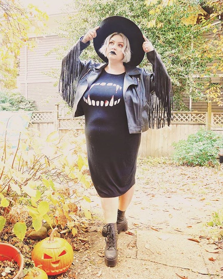 Plus-Size Influencer Margot Meanie posing for a picture in black dress and black leather jacket.