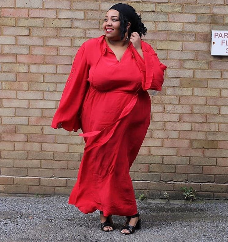 Plus-Size Influencer Mayah Camara wearing a long red dress with black sandals. 
