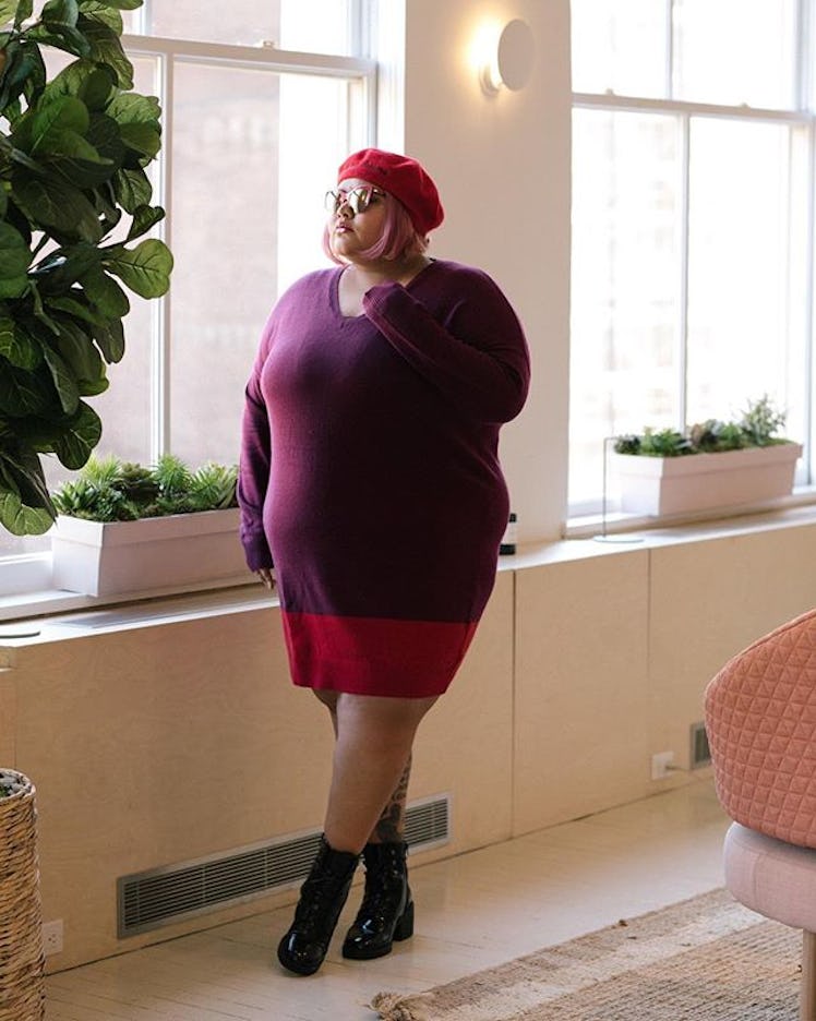 Plus-Size Influencer Ushshi wearing red beret while posing for picture.