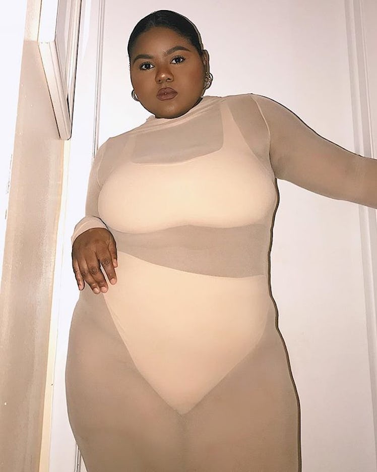Plus-Size Influencer Stacey wearing skintight, see-through, baby pink outfit.