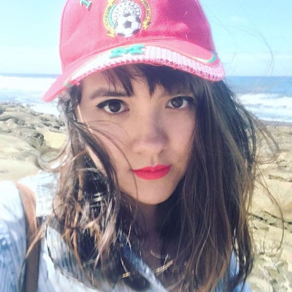 Erica Maria Cheung, an Asian-Latinx woman taking a selfie on a beach
