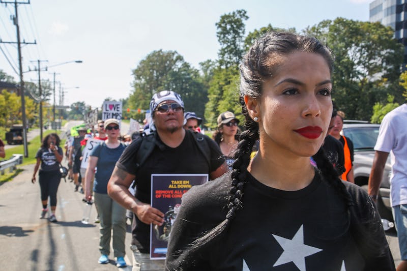 A black-haired Puerto Rican girl walking with a group of people down a street