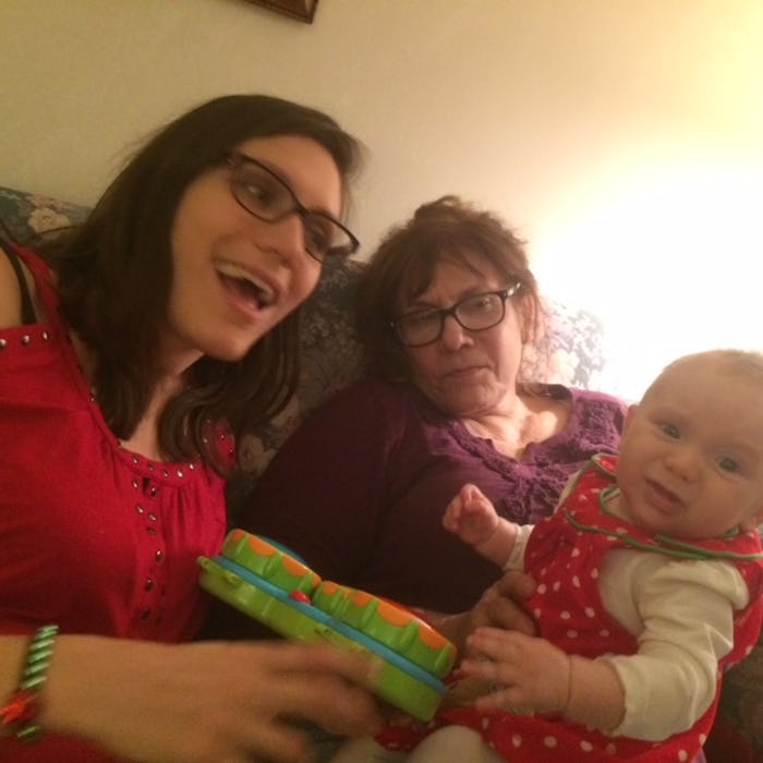 A newborn baby sitting next to its mother and grandmother