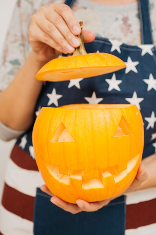 A woman's hands holding a jack-o'-lantern is the perfect pose to pair with pumpkin quotes for Instag...