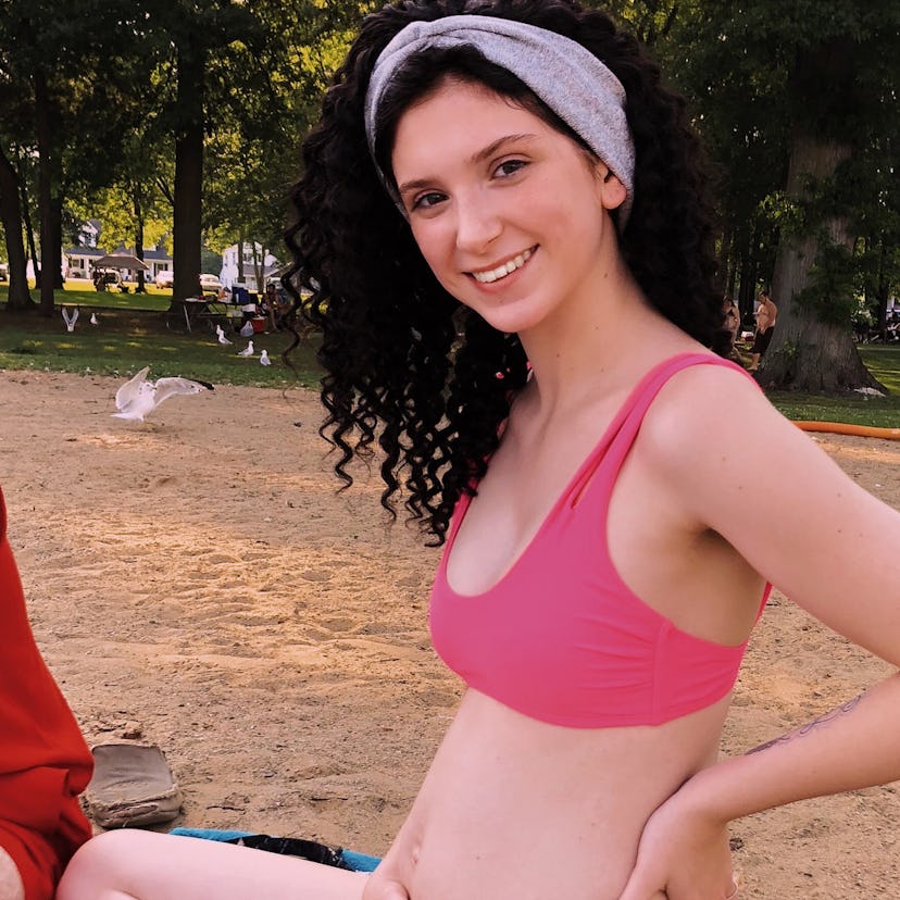 McKayla holding her belly while posing on a beach