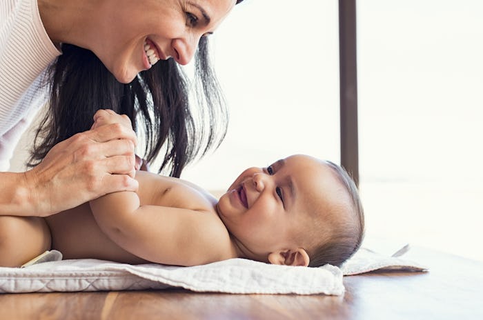 A mother playing with her newborn baby