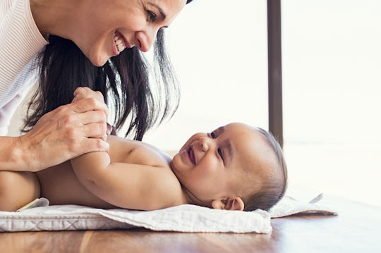 A mother playing with her newborn baby