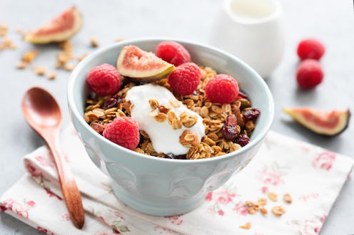 A bowl of granola with raspberries, figs and yogurt.