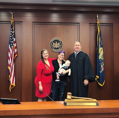 Dese'Rae L. Stage holding her baby while standing at the court next to her partner and the judge on ...