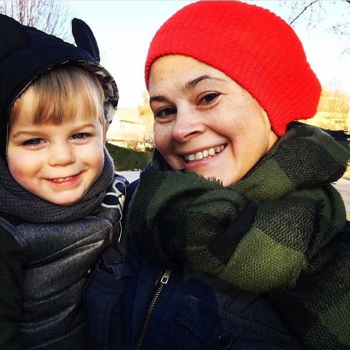 Kelly Green holding her son as they both smile for a selfie wearing winter clothing