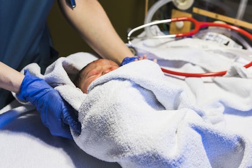 A nurse carrying a newborn baby