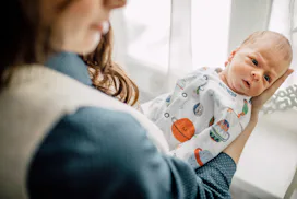 A mother holding her newborn baby in her arms