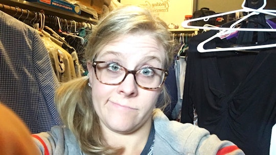 A mom with glasses taking a selfie in a messy closet 