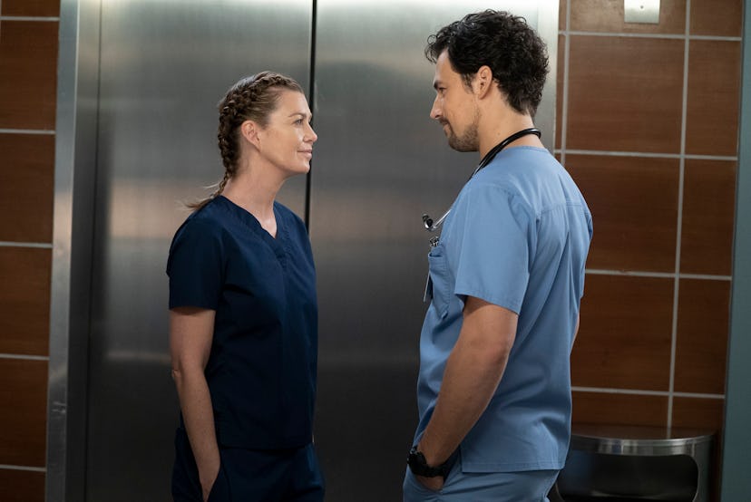 Meredith Grey and DeLuca standing in front of the elevator and looking into each other
