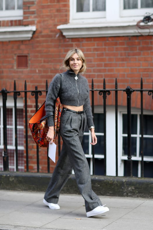 Woman walking on the street wearing a grey outfit. 