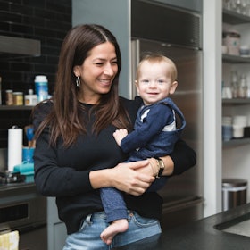Rebecca Minkoff holding her son in her kitchen