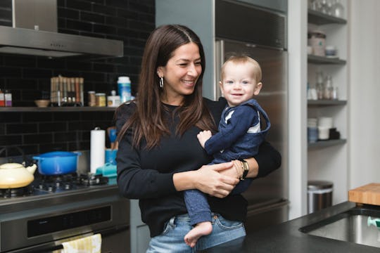 Rebecca Minkoff holding her son in her kitchen