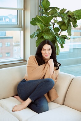 Laura Prepon posing for photo while sitting on a couch
