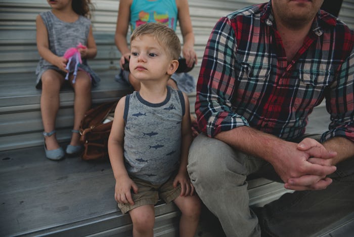 A toddler boy standing next to his boy