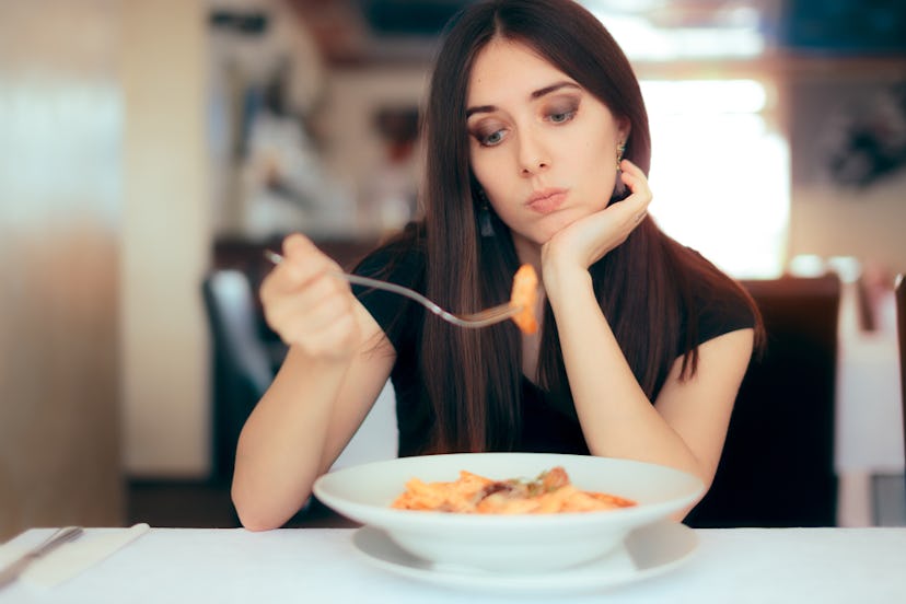 A woman with irregular appetite eating pasta